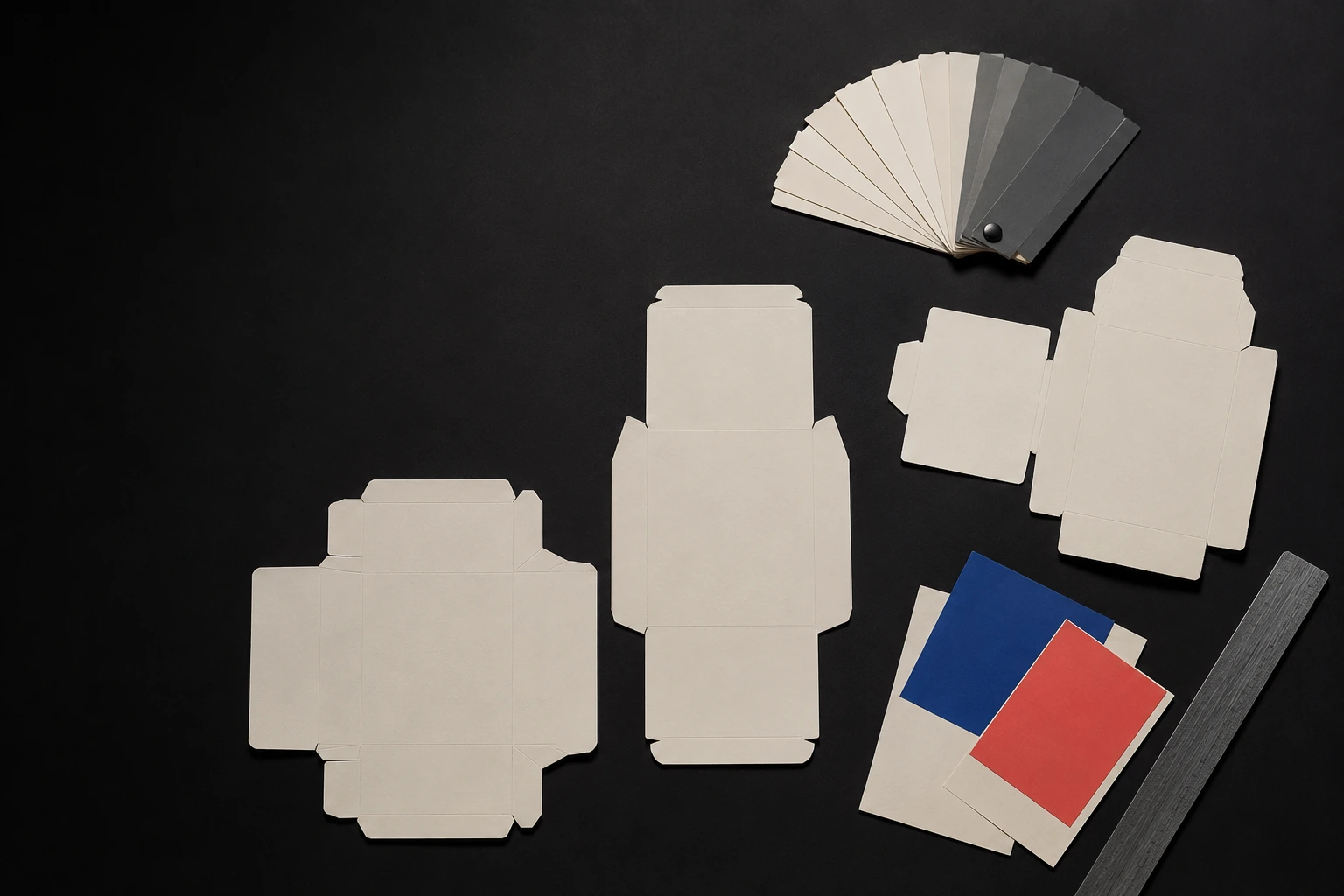 Production drawings, material swatches and printed colour references arranged on a dark project table